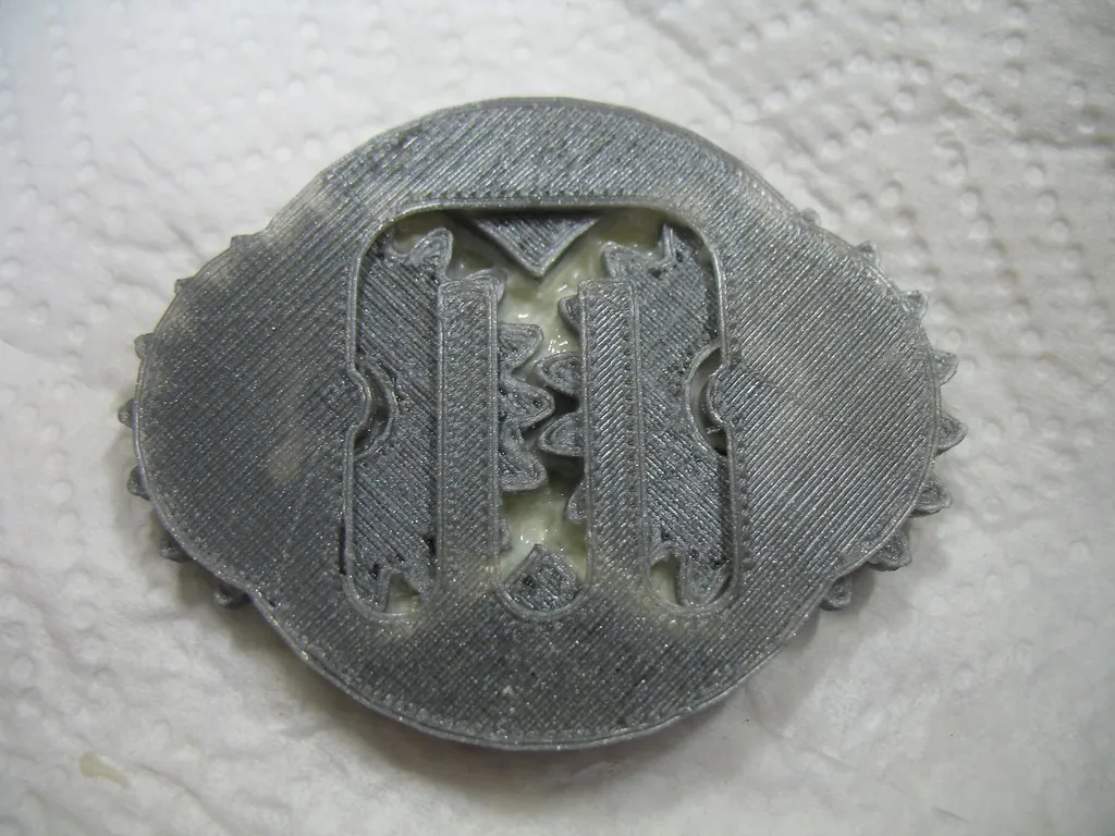 A grey printed gearbox seen from above, with whitish, partly dissolved PVA support still sitting between the gears